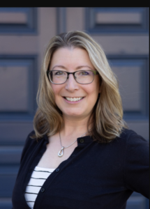 a woman wearing glasses and a black cardigan
