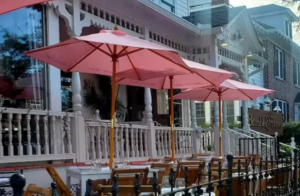 a row of tables with umbrellas on a sidewalk