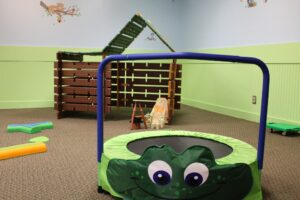 a play room with a green and blue trampoline