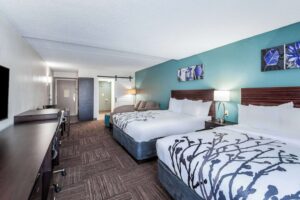 a hotel room with two beds and a flat screen tv