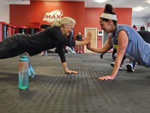 two women doing push ups in a gym