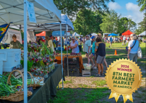 a group of people standing around a farmers market