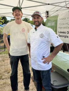 a couple of men standing next to each other under a tent