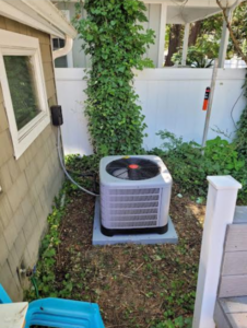 a small air conditioner in a yard next to a house