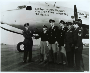 a group of men standing in front of an airplane
