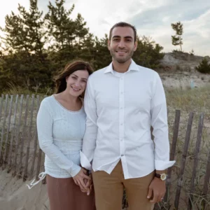 a man and woman standing next to each other on a beach