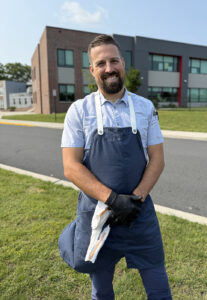 a man standing in the grass with his arms crossed