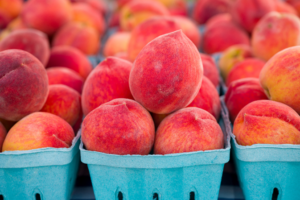a bunch of peaches sitting in blue baskets