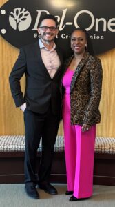a man and a woman standing in front of a sign