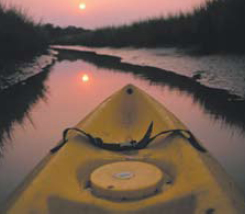 a yellow kayak sitting on the side of a river