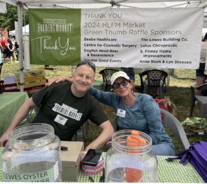 a man and a woman sitting at a table under a tent