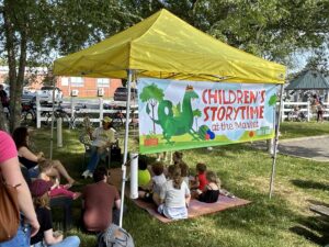 a group of children sitting under a yellow tent